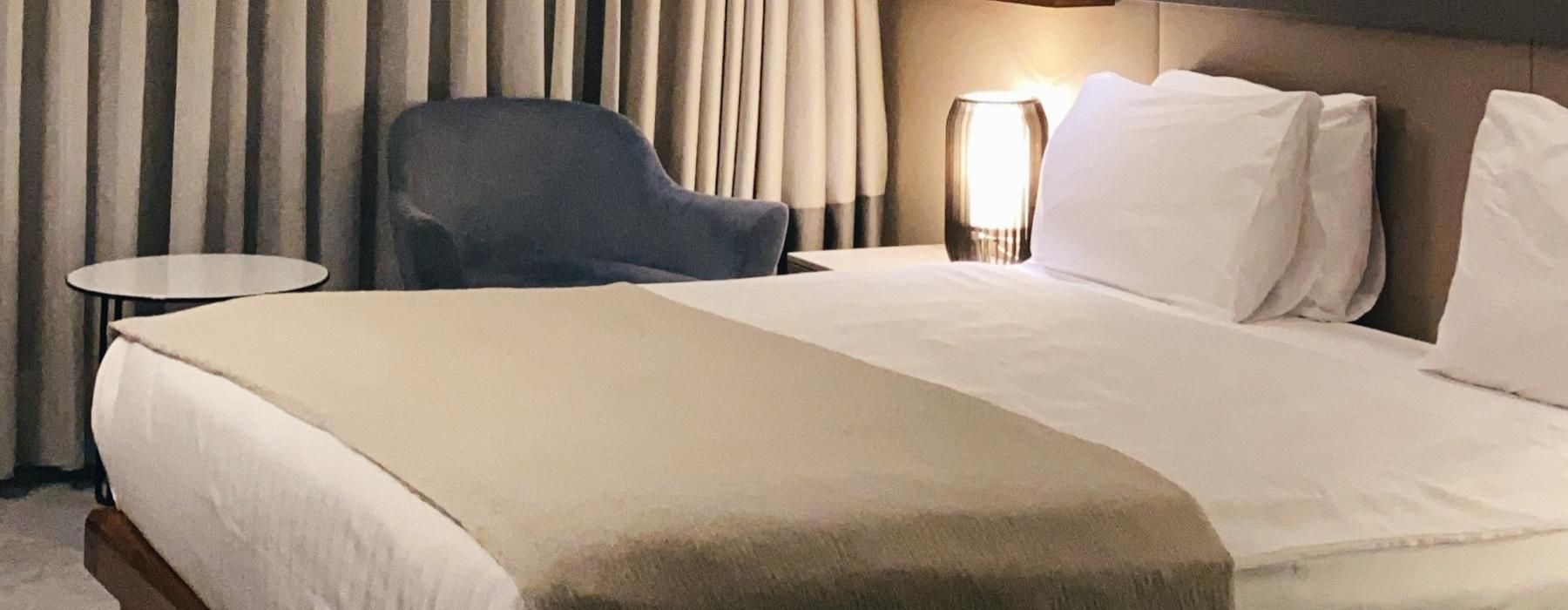 a bed with a chair and a table in the background